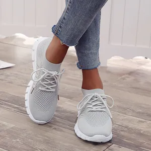 Nahaufnahme hellgrauer, atmungsaktiver Fly-Knit-Walking-Schuhe aus Mesh für Damen