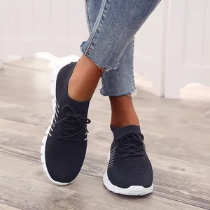 Nahaufnahme von atmungsaktiven schwarzen Fly-Knit-Mesh-Sneakern mit weißer Plateausohle.