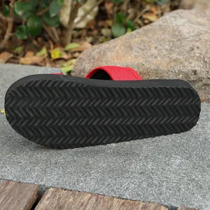 Détail de la semelle antidérapante en zigzag des chaussons en maille rouge pour femme