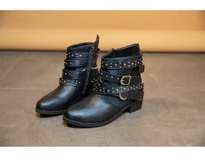 Detailansicht schwarzer Punk-Stiefeletten mit goldenen Nieten und Schnallenriemen.