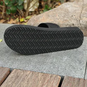 Vue détaillée de la texture antidérapante en zigzag sur la semelle noire de la pantoufle