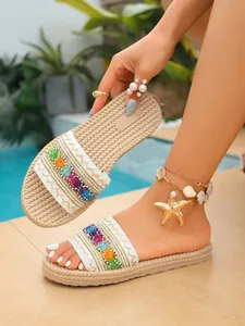 Vista detallada de sandalias planas estilo étnico con bordados coloridos en tiras