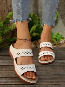 Sandales rétro blanches à semelle plateforme et design ajouré portées par un mannequin