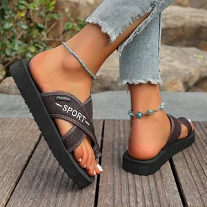 Vue détaillée de profil des tongs noires à plateforme pour femmes sur bois extérieur