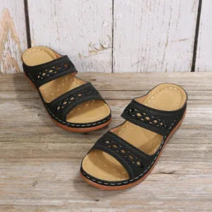 Vue détaillée des sandales compensées noires rétro avec des brides ajourées décoratives