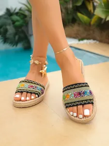 Detalle de chanclas étnicas bordadas con suela de cuerda para la playa en el verano.