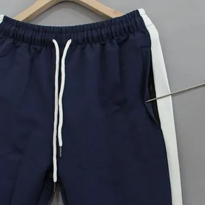 Close-up detail of navy blue athletic pants featuring a secure zippered side pocket