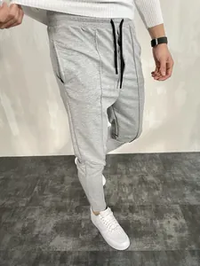 Dettaglio dei pantaloni sportivi slim fit grigi da uomo con coulisse e cuciture a vista