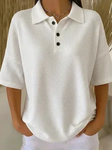 Close-up detail of white waffle knit short sleeve polo shirt featuring button collar.