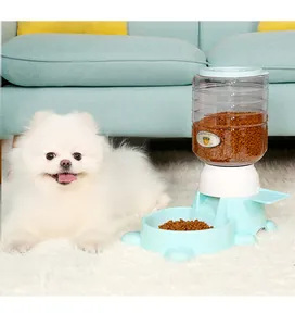 Chien Poméranien blanc posant à côté d'un distributeur automatique de croquettes bleu