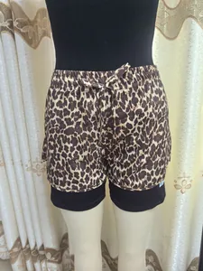 Dettaglio di pantaloncini sportivi 2-in-1 da donna con stampa leopardata e coulisse.