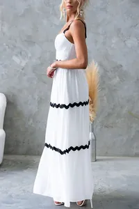 Détail de profil d'une robe longue blanche avec bordure en dentelle noire ondulée