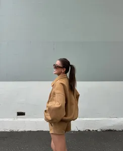 Seitenansicht eines Retro-Sets aus kamelbraunem Wildleder mit Jacke und Shorts auf Model.