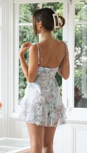 Back view of a floral print chiffon backless mini dress with ruffle details.