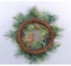 Detail eines rustikalen Weihnachtskranzes mit Kiefernnadeln, Reben, Zapfen und Juteband-Deko.