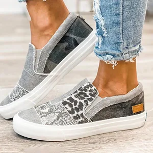 Primer plano de zapatos de lona tipo slip-on para mujer con diseño patchwork animal
