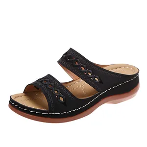 Détail de sandales compensées vintage noires avec découpes et surpiqûres blanches