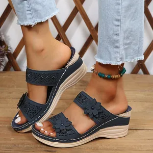 Detailed view of navy blue wedge sandals featuring 3D flowers and rhinestone accents
