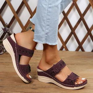 Detailed view of purple wedge sandals featuring elegant flower accents and rhinestones