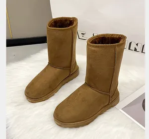 Classic brown tall snow boots with warm faux fur lining on a white rug.