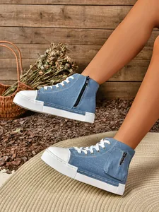 Gedetailleerde weergave van blauwe denim high-top sneakers met rits en een witte zool