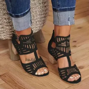 Détail de sandales noires ajourées à talons carrés, bout ouvert et fermeture éclair