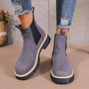 Vista detallada de botas Chelsea de ante gris con suela gruesa y punta redonda