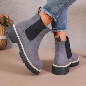 Detalle de botines de ante gris con paneles elásticos laterales y suela de plataforma.