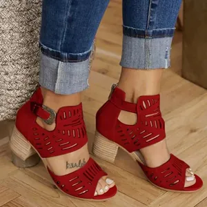 Gros plan sur d'élégantes sandales rouges ajourées à talons épais avec fermeture éclair et boucle