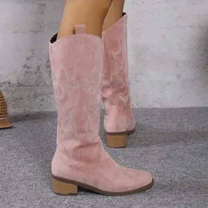 Vue détaillée des bottes de cow-boy en daim rose avec broderie vintage sur un mannequin