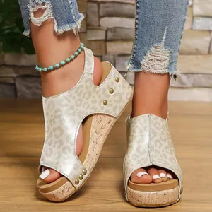 Primer plano de sandalias con cuña de leopardo para mujer con remaches dorados y corcho