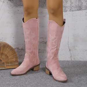 Détail de bottes de cowboy roses en daim avec broderie blanche et fermeture éclair latérale