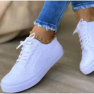 Vue détaillée de chaussures brogue blanches à lacets avec perforations.