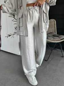 Detailed view of shiny silver wide-leg trousers with drawstring elastic waist