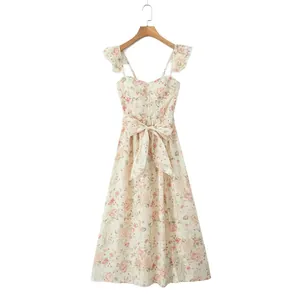 Detail view of a floral print dress with ruffle sleeves and a waist tie bow.