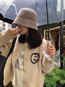 Detail of Korean style knit cardigan with embroidered smiley face on a model