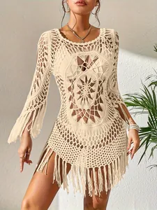 Λεπτομερής προβολή κρεμ boho πλεκτής μπλούζας παραλίας με περίπλοκα σχέδια και κρόσσια