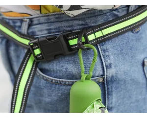 Detail of reflective dog leash belt with green poop bag dispenser at waist
