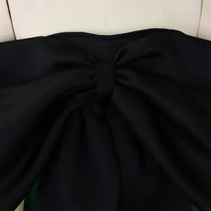 Dettaglio ravvicinato della trama del tessuto e del fiocco del top a fascia nero