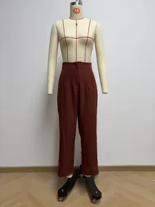 Detailed view of women's high-waisted reddish-brown straight leg trousers on mannequin