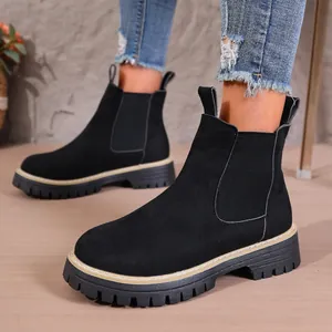 Primer plano de botas Chelsea de ante negro con punta redonda y suela de plataforma