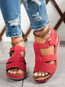 Close-up view of stylish red platform sandals for women with retro perforated design