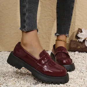 Λεπτομερής άποψη των μπορντό λουστρίνι loafers με πλατφόρμα και ανάγλυφο κροκό