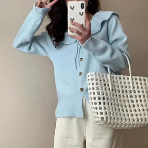 Detail view of light blue doll collar knit cardigan with gold heart buttons