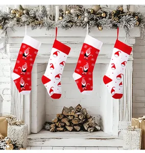 Set of four red and white knitted Christmas stockings hanging on a fireplace mantel