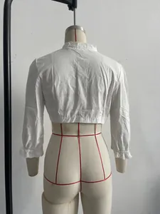Dettaglio vista posteriore di una camicetta corta in pizzo bianco vintage su manichino
