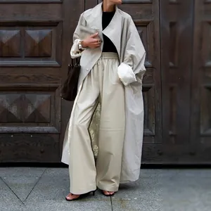 Fashionable light apricot oversized trench coat with large lapels and loose silhouette