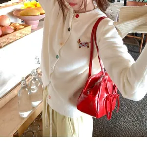 Soft white knit cardigan featuring vibrant colorful buttons and a cute dog embroidery detail