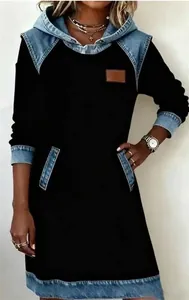 Dettaglio di un abito con cappuccio nero da donna con design patchwork in denim blu.