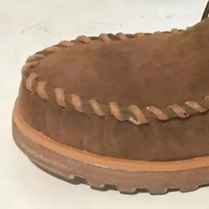 Detailed view of brown suede platform short boot featuring stylish braided edge detailing